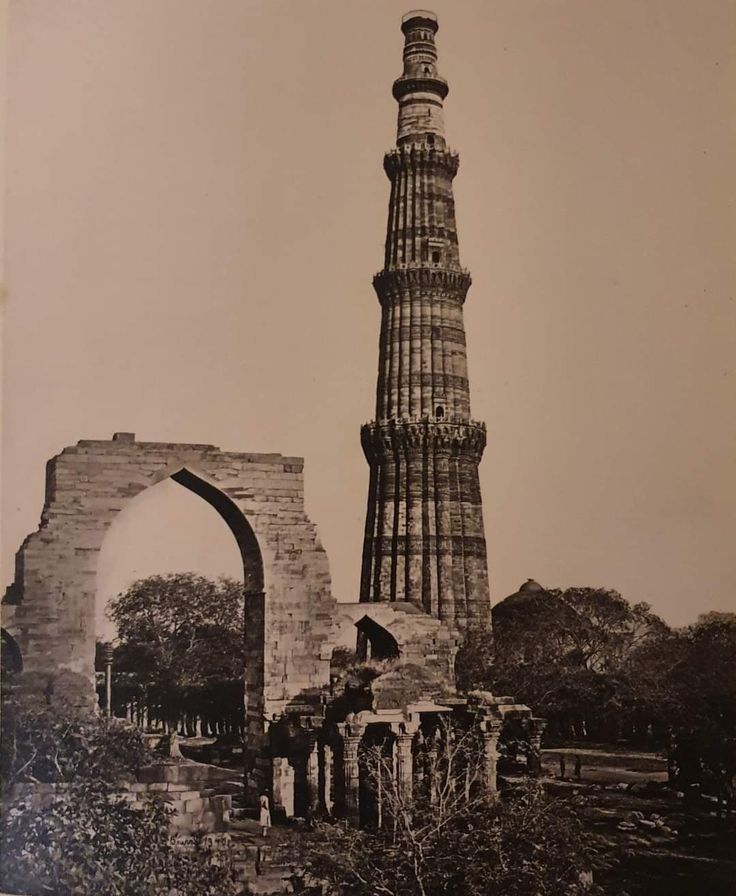 Archival photograph of Qutub Minar and the surrounding archaeological ruins